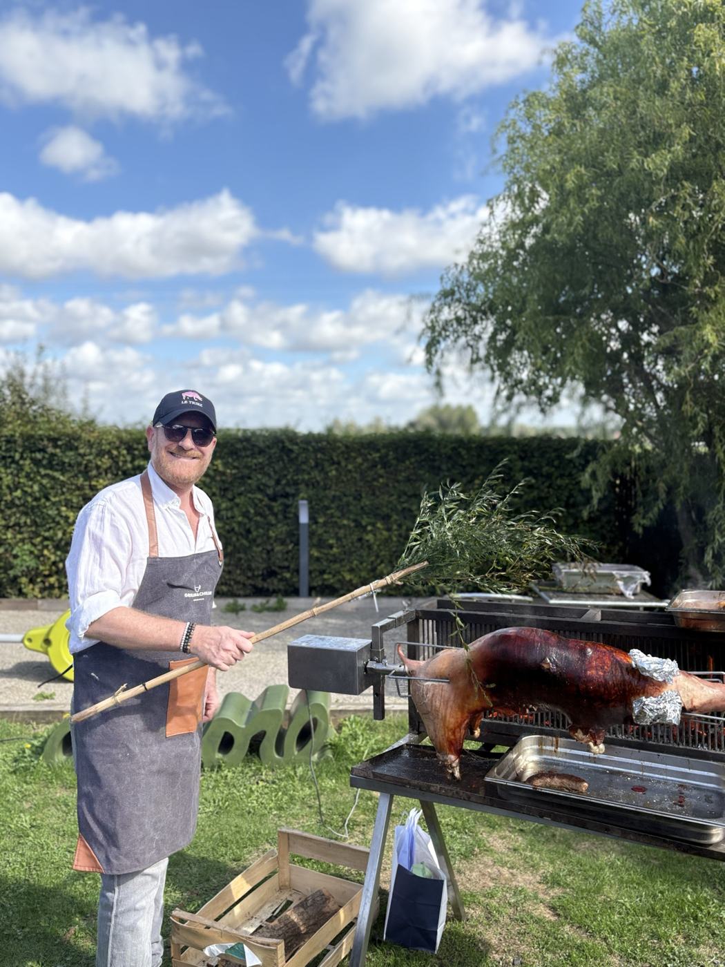 Alex à la découpe d'un cochon de lait lors d'une réception en extérieur