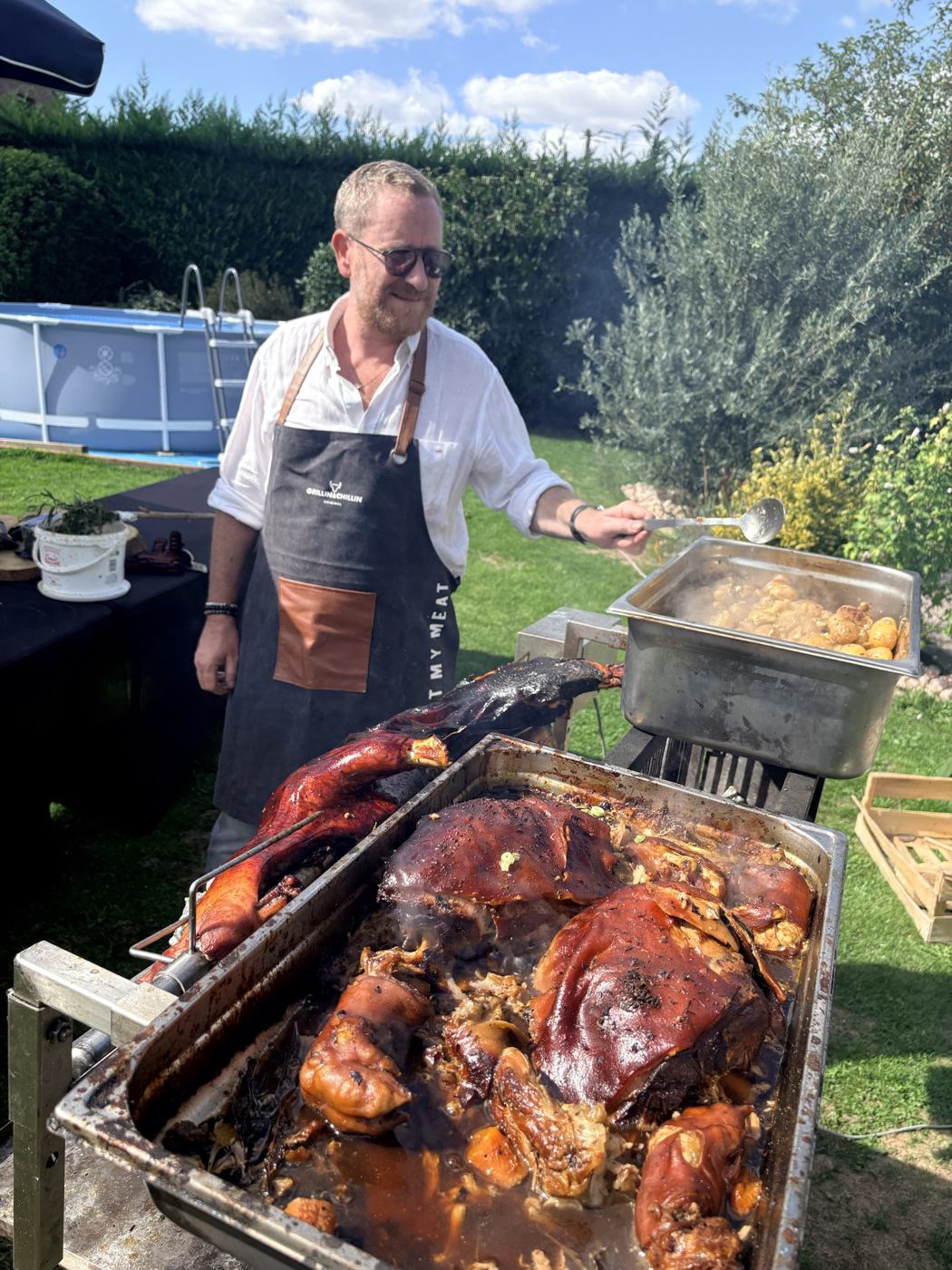 Alex devant un cochon de lait à la broche lors d'une prestation de traiteur
