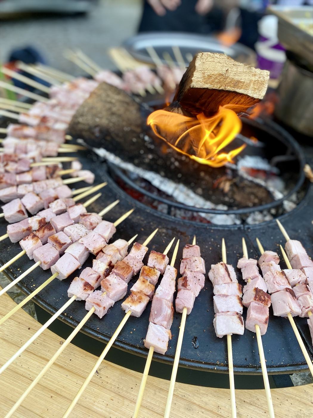 Brochettes de porc disposées en couronne autour du feu