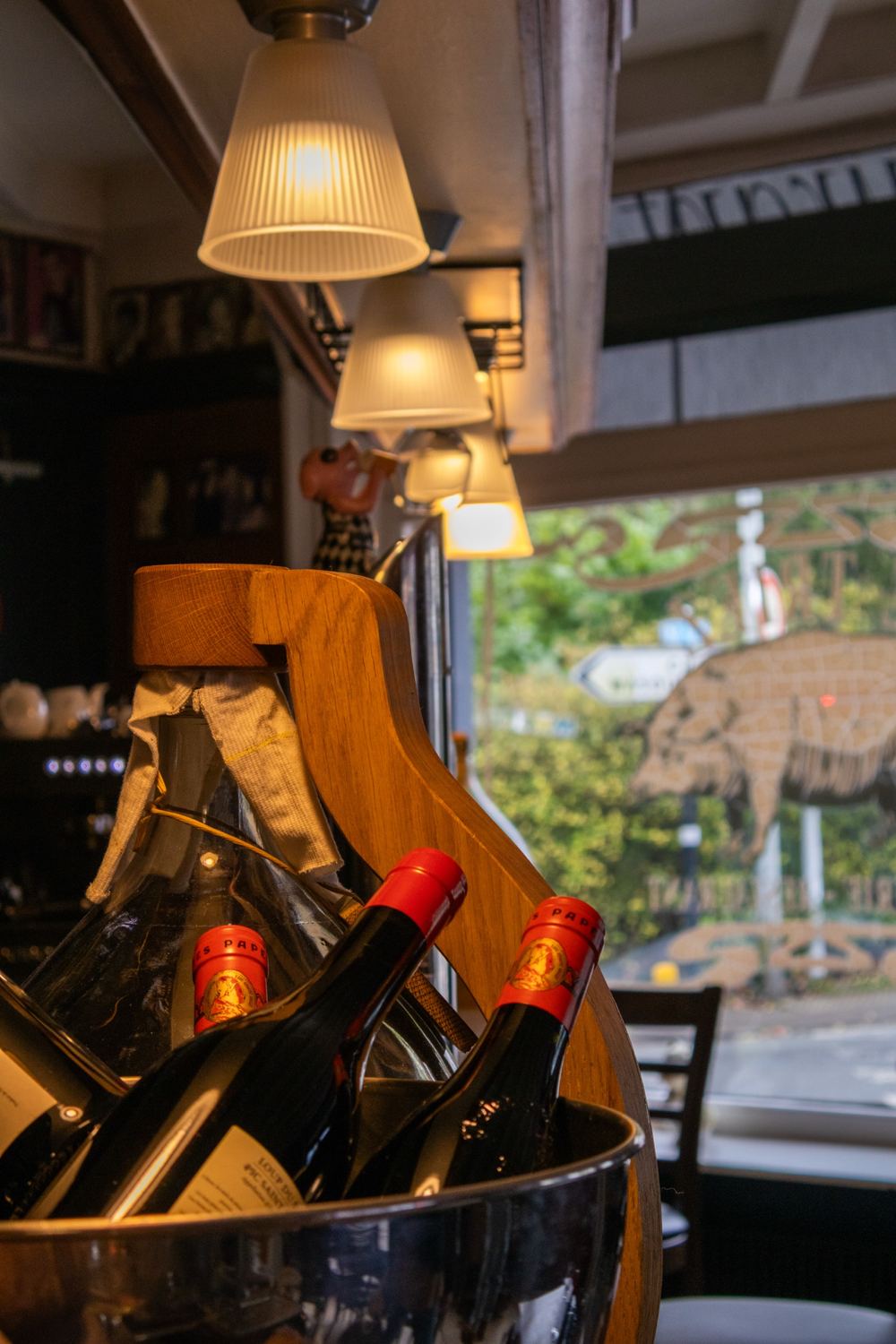 Bouteilles de vin et grande bonbonne au bar du Triez