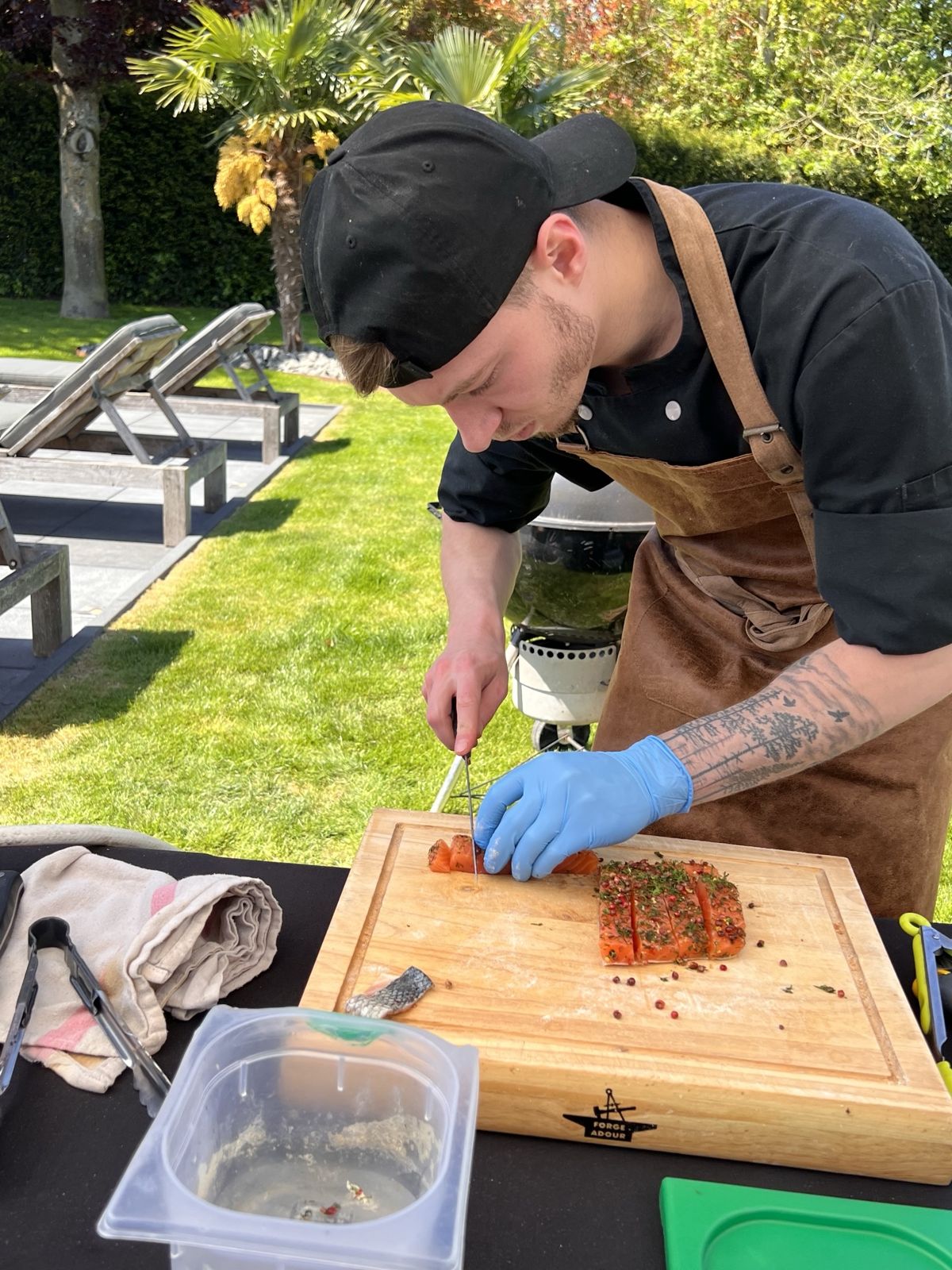 Jordan, chef du Triez, découpe un saumon mariné lors d'une prestation en extérieur