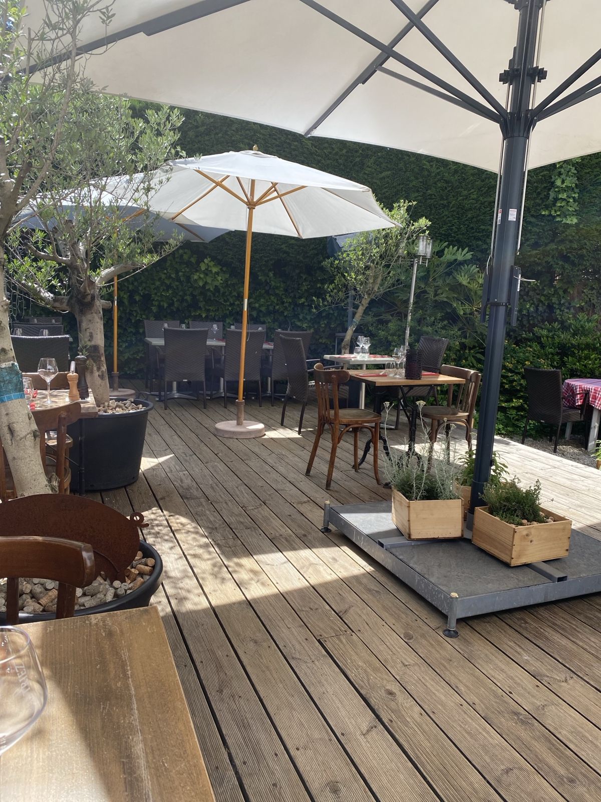 La terrasse arborée du Triez, parasols et tables en bois